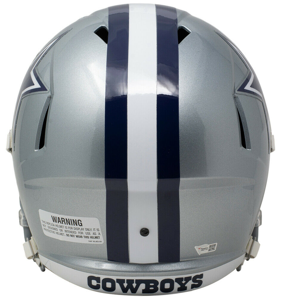 The Sports Integrity CeeDee Lamb Signed Dallas Cowboys Full Size Speed Replica Helmet features a silver design with a white and blue center stripe, "COWBOYS" on the lower back, and a warning label on the left side.
