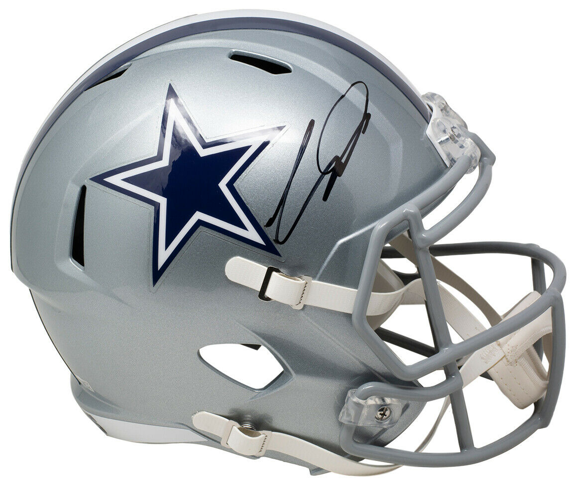The Sports Integrity CeeDee Lamb Signed Dallas Cowboys Full Size Speed Replica Helmet features a silver finish, blue star logo, black autograph, gray facemask, and white chin strap.