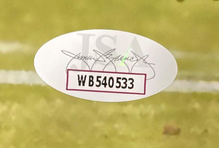 Close-up of an oval JSA authentication sticker with serial number WB540533 and faint signature on a Philadelphia Eagles 11x14 blocking photo signed by Jeremiah Trotter Jr (Sports Integrity).