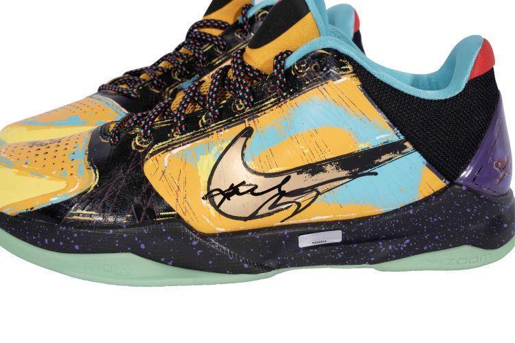 A vibrant Nike Zoom Kobe V Prelude basketball shoe by Sports Integrity, signed by Kobe Bryant, features a black swoosh, multicolor paint splatter design, and teal, yellow, purple, and black accents. Lakers Finals MVP Panini edition.