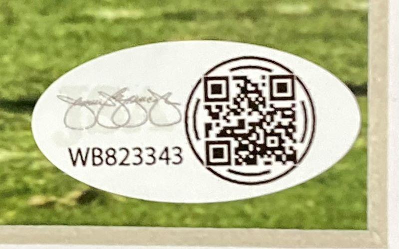 An oval white sticker with a black QR code, printed signature, and code WB823343, from Sports Integrity's Tyler Warren Signed Framed 8x10 Penn State Nittany Lions Photo JSA, is shown on green grass.