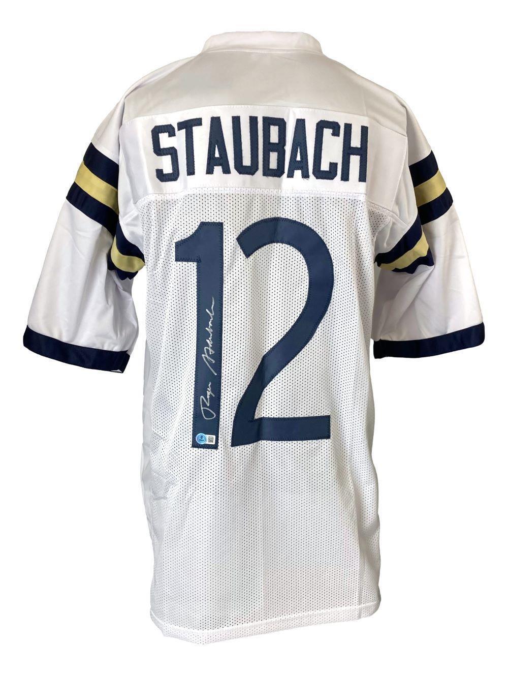 The Sports Integrity Roger Staubach Navy Signed White Football Jersey BAS features blue and gold sleeve stripes, "Staubach" and number 12 on the back, with Staubach’s signature in white ink.