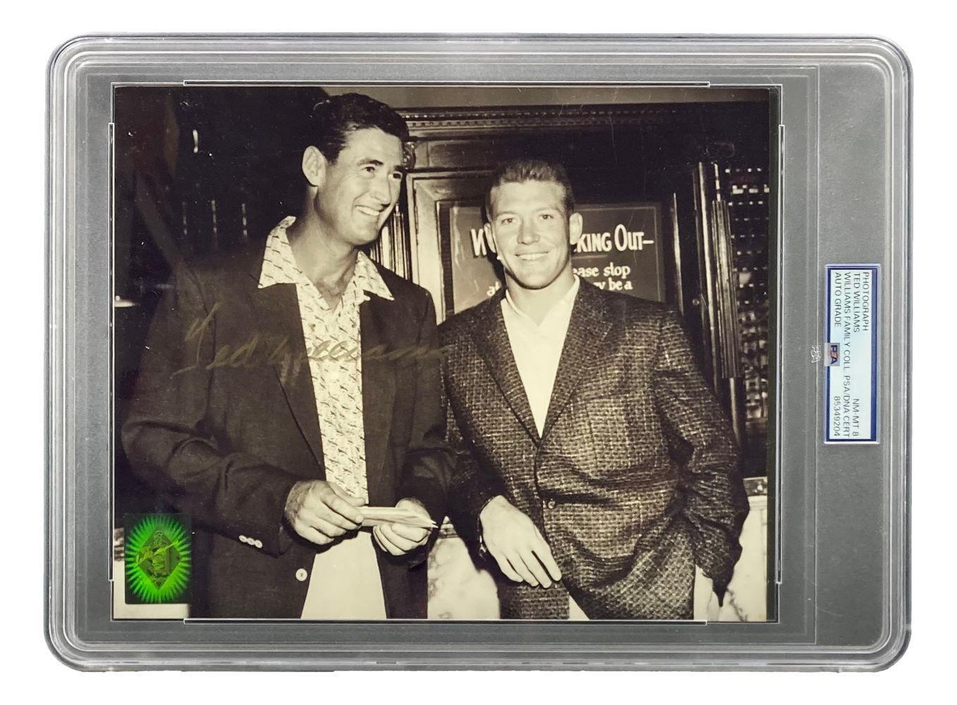 The Sports Integrity Ted Williams Signed Slabbed 8x10 Red Sox Photo with Mickey Mantle (PSA NM-MT 8) shows both men in jackets smiling indoors, encased in a clear holder with a right-side label and green holographic sticker at bottom left.