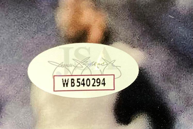 A close-up of an oval sticker with WB540294 in bold black text and a faint signature, affixed to a Brandon Graham Signed 8x10 Philadelphia Eagles Black Jersey Photo by Sports Integrity.