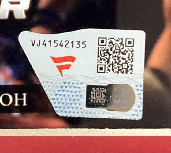 A close-up of a sticker featuring code VJ41542135, two QR codes, and a red angular logo on white-blue pattern, used for authentication of the Sports Integrity Roman Reigns Signed Framed 8x10 WWE Photo Fanatics.