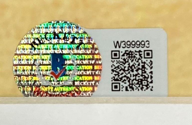 A Beckett authentication sticker with a blue checkmark/shield is beside a QR code and serial W399993 on a white background for the Sports Integrity Cole Hamels Signed Framed 16x20 Phillies Photo 08 WS MVP Inscribed BAS ITP.