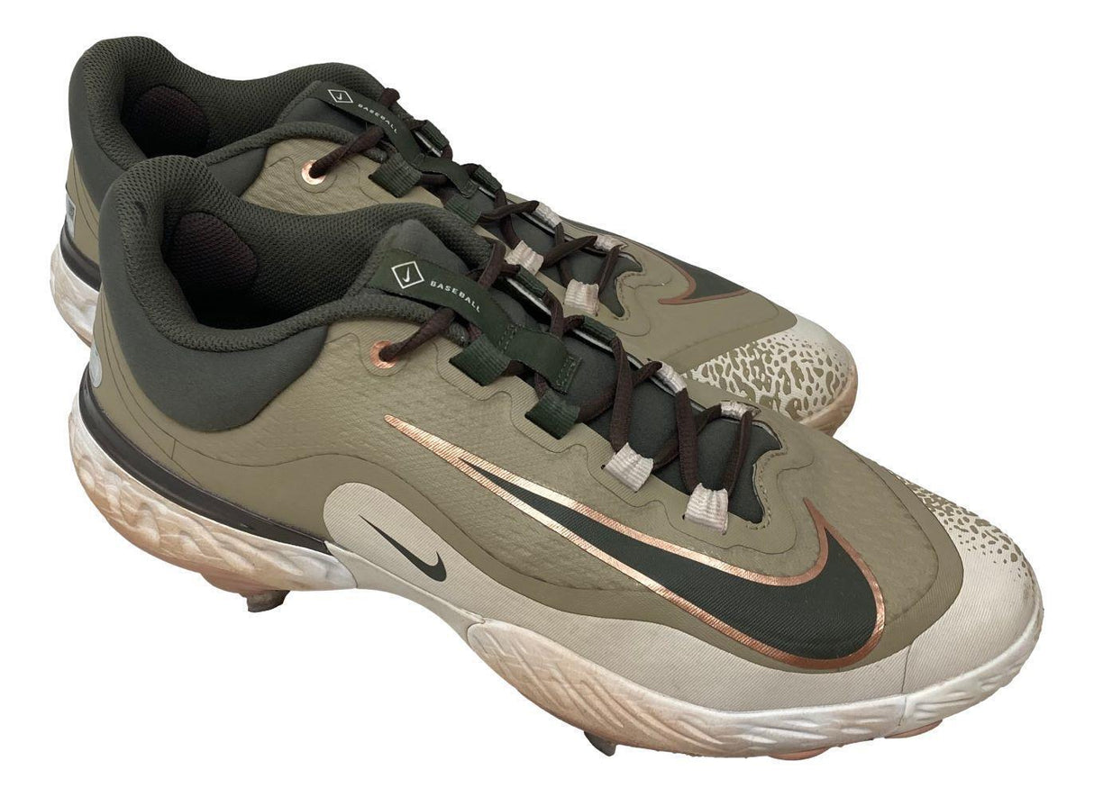 A pair of Adley Rutschman 2024 Game Used Baltimore Orioles Nike Cleats 2 by Sports Integrity, featuring olive green and beige with bronze accents, black laces, and textured white soles, displayed on a white background.