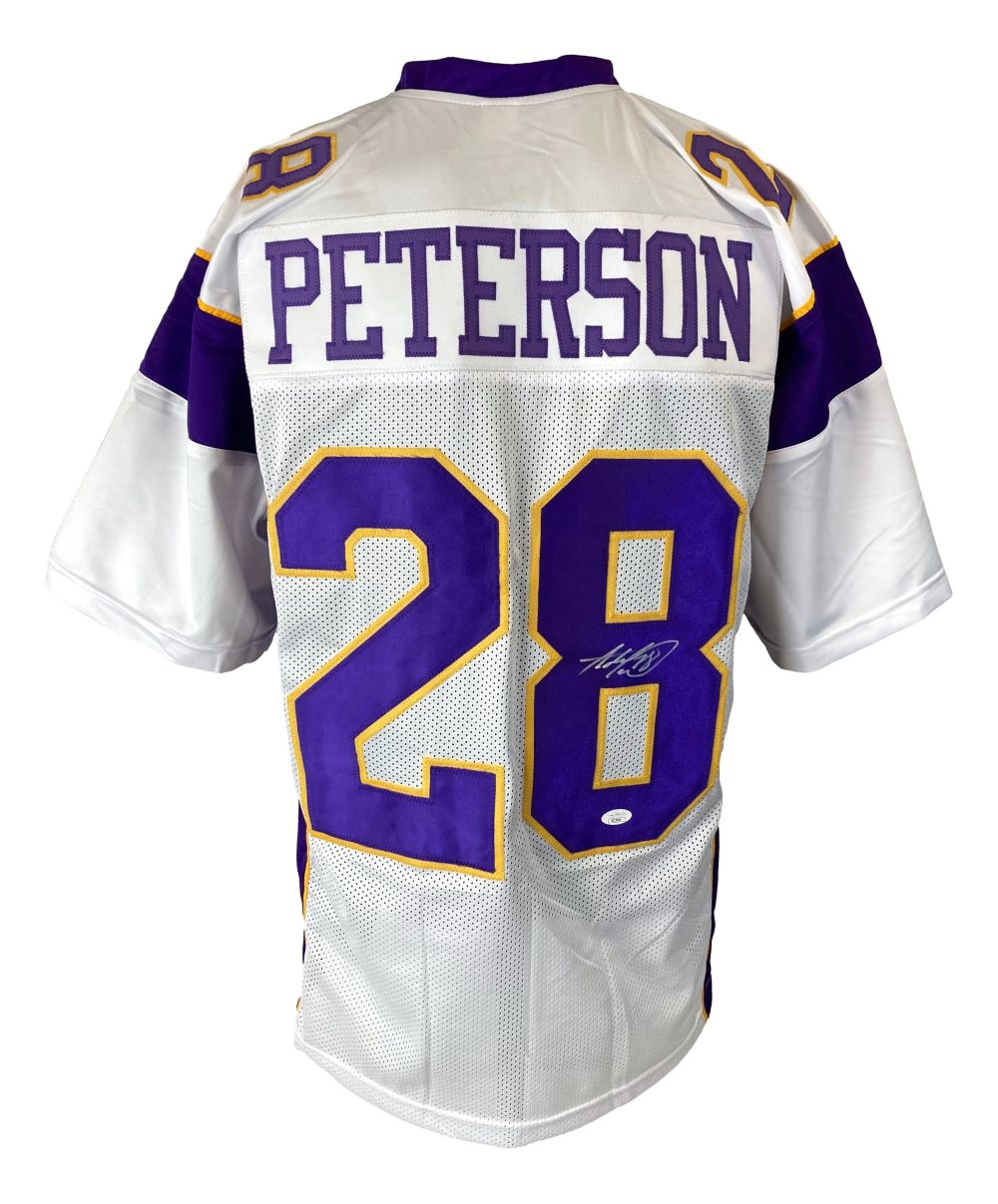A white Minnesota football jersey by Sports Integrity with purple and yellow trim, featuring "PETERSON" and number 28 on the back. The lower part of the "8" is autographed. This Adrian Peterson jersey is JSA authenticated.
