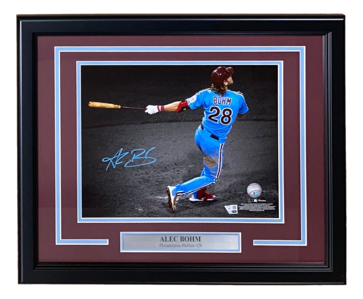 Alec Bohm Signed Framed 11x14 Philadelphia Phillies photo by Sports Integrity, features Bohm in a blue uniform swinging a bat, autograph and #28 inscription. Includes plaque and maroon matting. Authenticated by Fanatics.