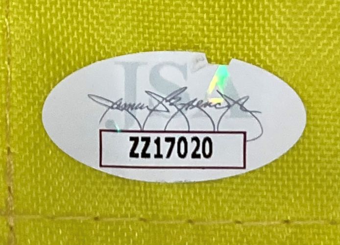 An oval authentication sticker appears on the yellow textured surface of the Arnold Palmer Signed Framed Arnold Palmer Invitational Yellow Golf Flag by Sports Integrity, reading ISA with serial number ZZ17020 in bold black text inside a bordered white rectangle.