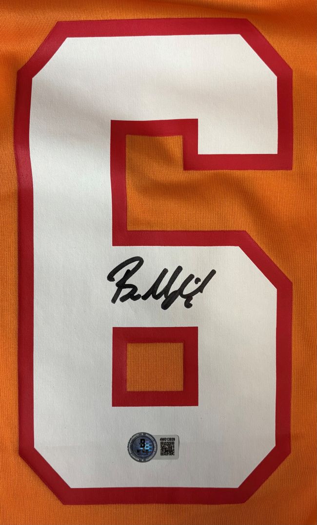 The Baker Mayfield Signed Tampa Bay Buccaneers Orange Nike Game Replica Jersey by Sports Integrity features a white number 6 with red outline on orange fabric, black autograph on the number, and a round QR authentication sticker below.
