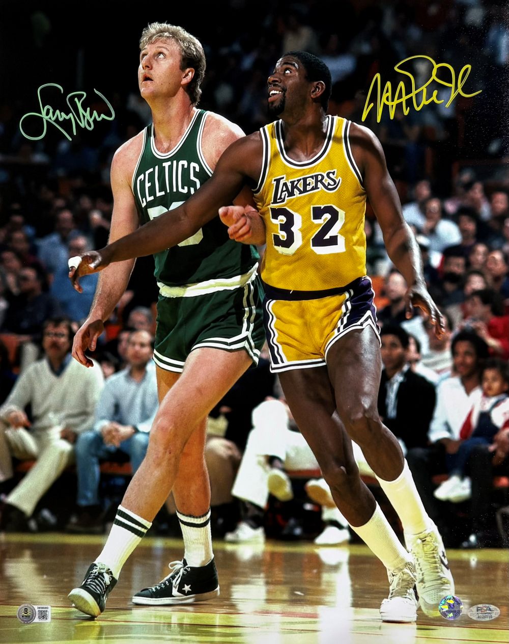 The Sports Integrity Larry Bird Magic Johnson Dual Signed 16x20 Boston Celtics Lakers Photo (PSA+BAS) captures both legends in action on the court, focused on play with an audience visible behind them.