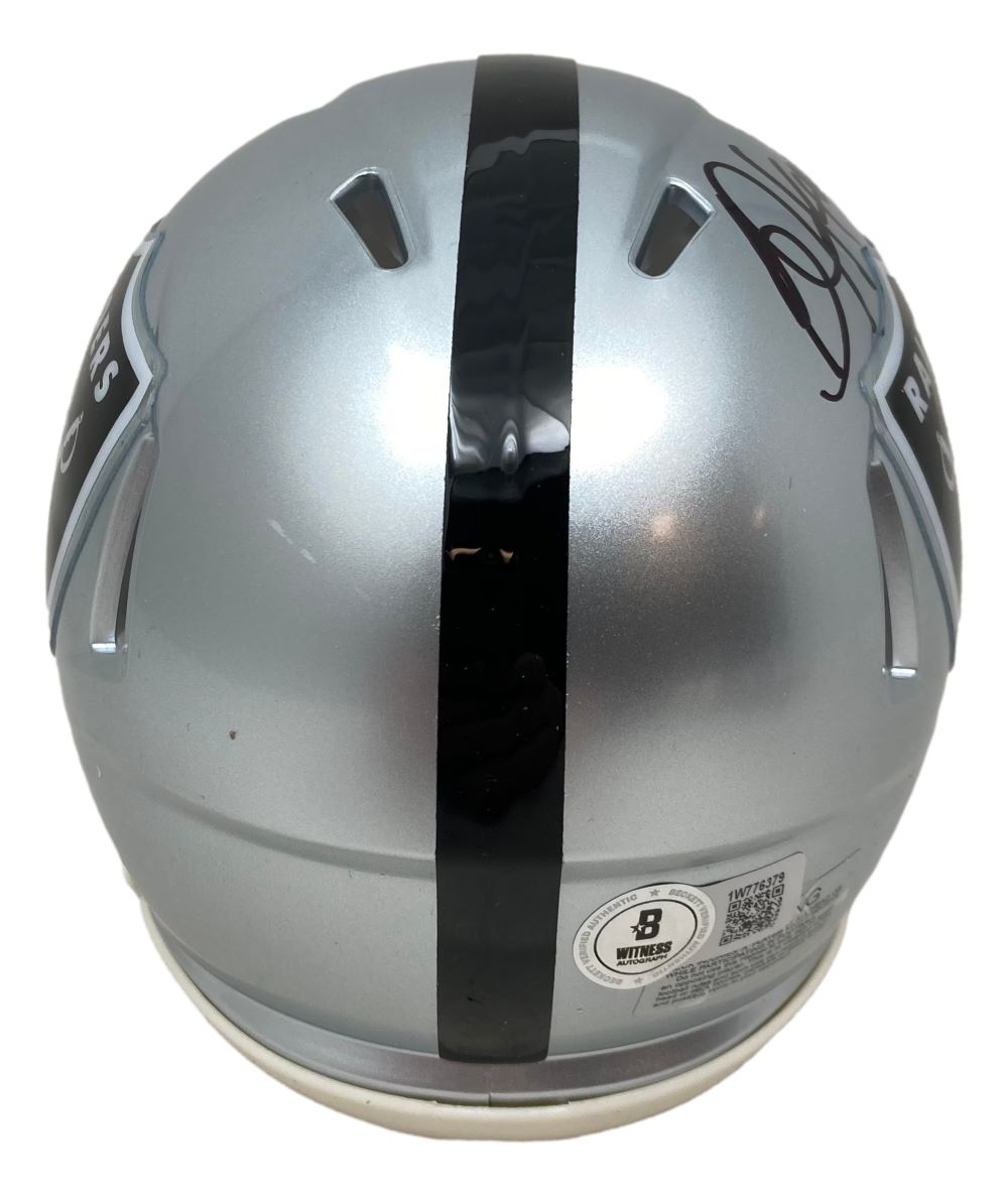 The Bo Jackson Signed Oakland Raiders Mini Speed Helmet by Sports Integrity features a silver design with a black center stripe, Raiders logos on each side, his signature on top, and a visible BAS ITP certification sticker.