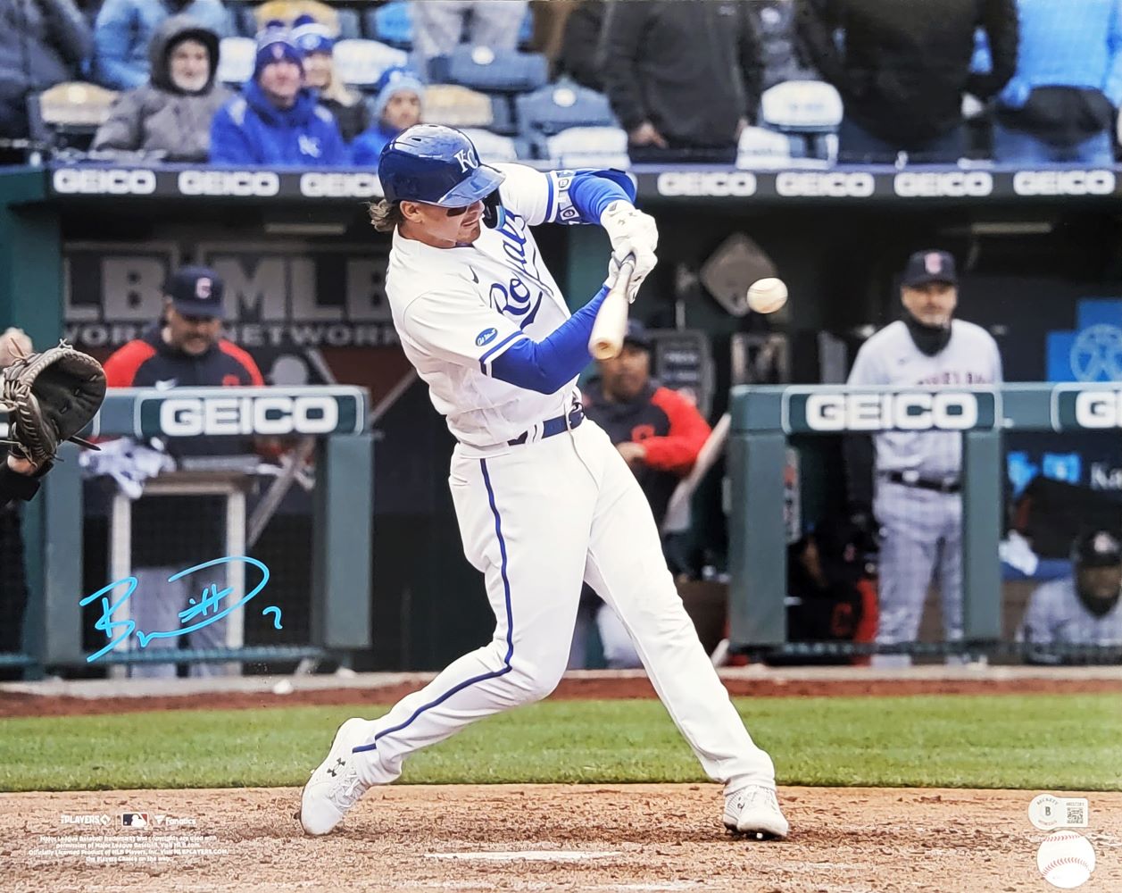 A Kansas City Royals player in white swings a bat during a game in this 16x20 photo, signed by Bobby Witt Jr in blue. Fans and opponents are seen in the background. Product: Sports Integrity Bobby Witt Jr Signed 16x20 Royals Photo BAS ITP.