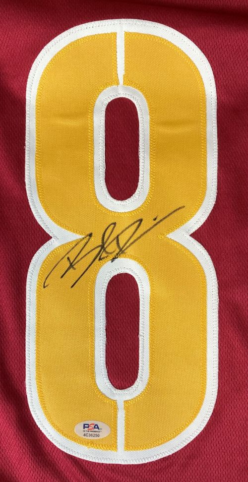 A maroon Sports Integrity football jersey features a large white-outlined yellow number 8, signed by Brian Robinson Jr, with a PSA/DNA hologram at the bottom of the digit.