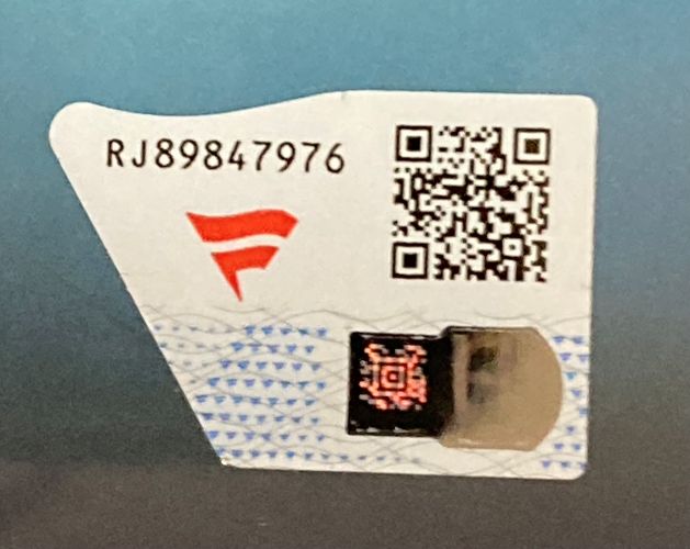 A close-up of a white security label with code RJ89847976, a red logo, two QR codes, and a holographic strip on the Bron Breakker Signed Framed 8x10 WWE Photo by Sports Integrity.