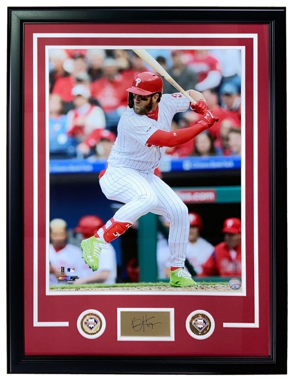 Sports Integrity Bryce Harper Framed 16x20 Philadelphia Phillies Photo features Harper mid-swing in a red helmet and white uniform, with a laser-engraved signature below and two commemorative coins. Crowd is visible in the background.