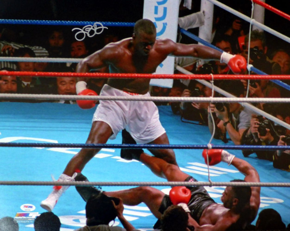 The Buster Douglas Signed 16x20 Mike Tyson Knockout Photo by Sports Integrity shows Douglas in white trunks standing over Tyson, who is falling to the canvas during a well-lit boxing match, authenticated by PSA/DNA.