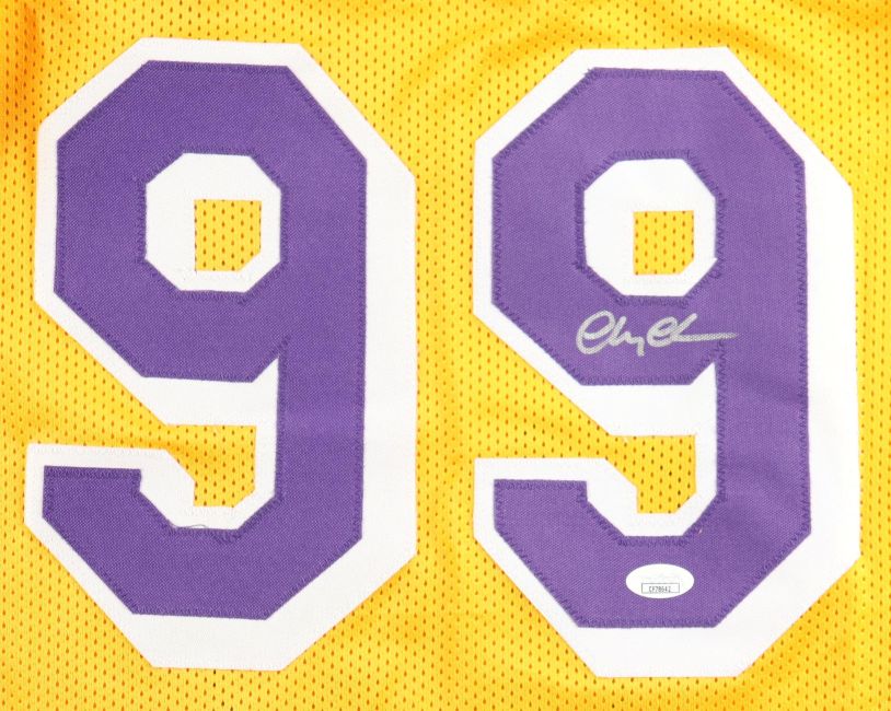The Sports Integrity Chevy Chase Signed Los Angeles Yellow Fletch Basketball Jersey features large purple and white number 99, a silver autograph on the right-side 9, and a JSA hologram for authentication.
