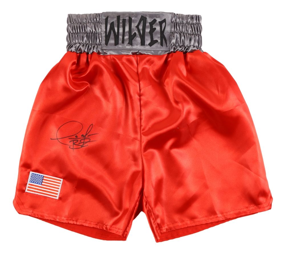 Sports Integrity Deontay Wilder Signed Custom Red Boxing Trunks BAS feature a gray elastic waistband labeled WILDER, an autograph on the left side, and a small American flag patch near the hem.