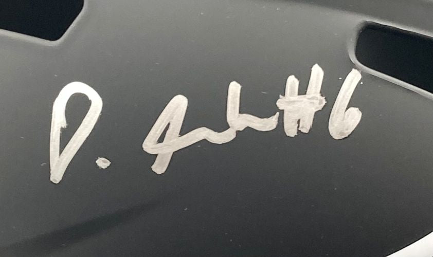 Close-up of a black Sports Integrity Eagles FS Eclipse Replica Helmet, signed in silver by Devonta Smith with "Super Bowl 59 LIX," featuring two vent holes above and right of the autograph.
