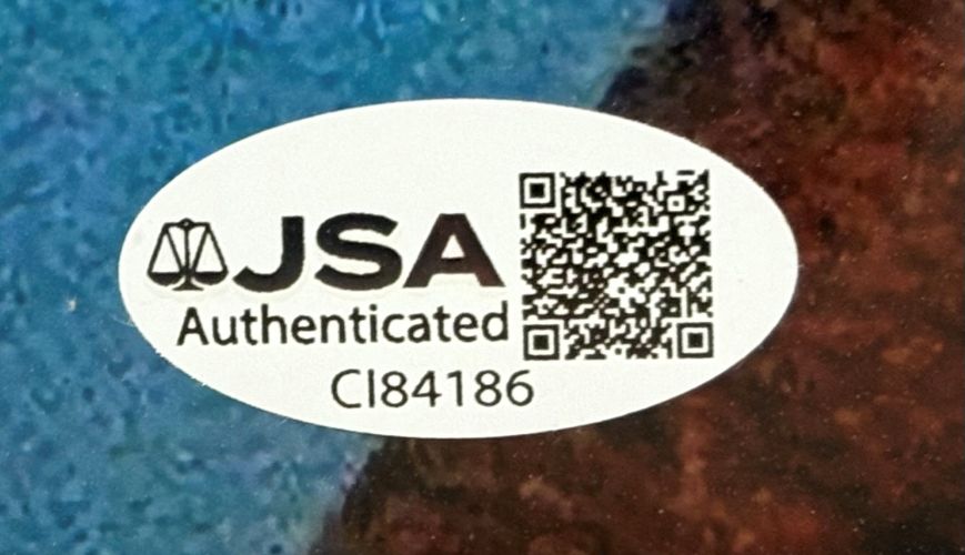 A JSA Authenticated oval sticker with QR code, justice scales logo, "JSA Authenticated," and code CI84186 is on the Sports Integrity Matthew De Merritt Signed Framed 11x14 ET Photo.