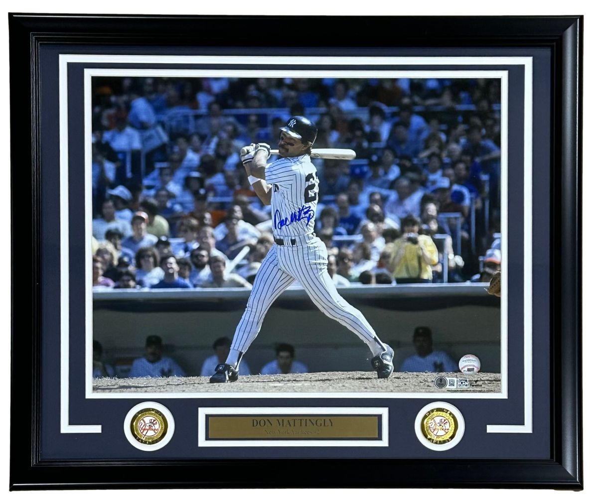 The Sports Integrity Don Mattingly Signed Framed 16x20 New York Yankees Photo BAS features Mattingly in a pinstripe uniform swinging a bat, signed in blue ink, with two gold medallions and a nameplate. Stadium crowd background.