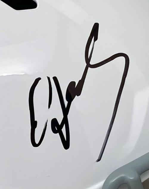 A close-up of an Edgerrin James autograph in bold, looping lines on a white Indianapolis Colts Full Size Speed Replica Helmet by Sports Integrity. The signature is black and slightly reflective.