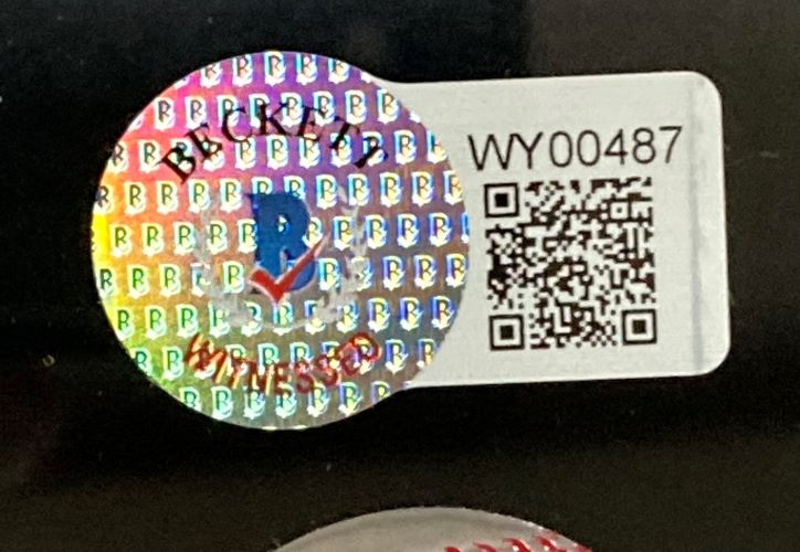 A holographic Beckett sticker (QR code, WY00487) is affixed to a black-framed "Ken Griffey Jr Ichiro Suzuki Signed Framed 16x20 Seattle Mariners Photo BAS" by Sports Integrity; part of a red-stitched baseball is seen at the bottom.