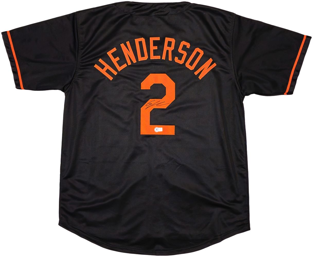The Sports Integrity Gunnar Henderson Baltimore jersey is black with orange trim, features "HENDERSON" and the number 2 on the back, plus a small autograph.