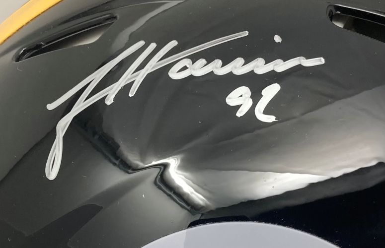 Close-up of a Sports Integrity Pittsburgh Steelers Authentic Speed Helmet, full size and black, autographed by James Harrison with "92" in silver marker. Features air vents and reflective surfaces. BAS authenticated.