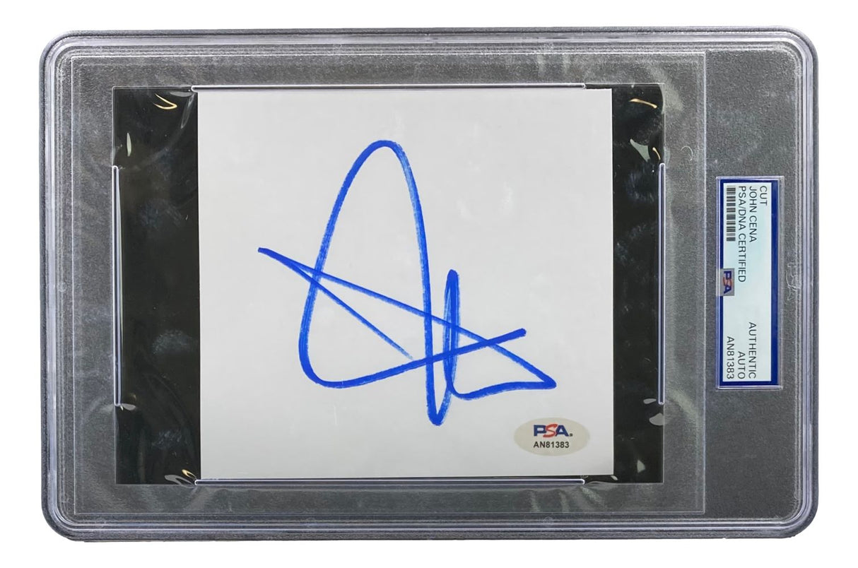 The Sports Integrity John Cena Signed Slabbed WWE Cut Signature (PSA AN81383) is a white card with a bold blue autograph, securely encased in clear plastic and authenticated by PSA with a label and certification tag on the right.