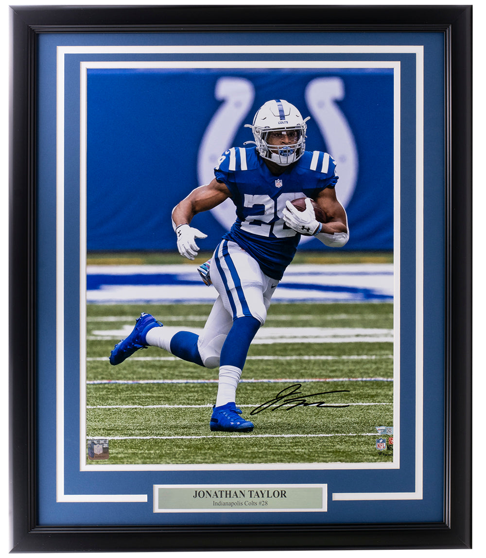 The Sports Integrity Jonathan Taylor Signed Framed 16x20 Indianapolis Colts Photo by Fanatics showcases Taylor in his blue uniform and includes a plaque with his name and team, making it a perfect display piece for fans.