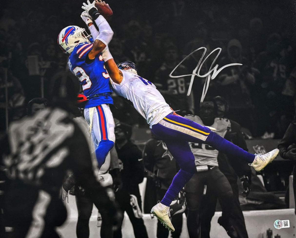 The Sports Integrity Justin Jefferson Signed 16x20 Minnesota Vikings Photo vs Bills BAS shows Jefferson reaching for the ball against a Bills player, with both athletes in color on a black and white background. Autograph is visible.