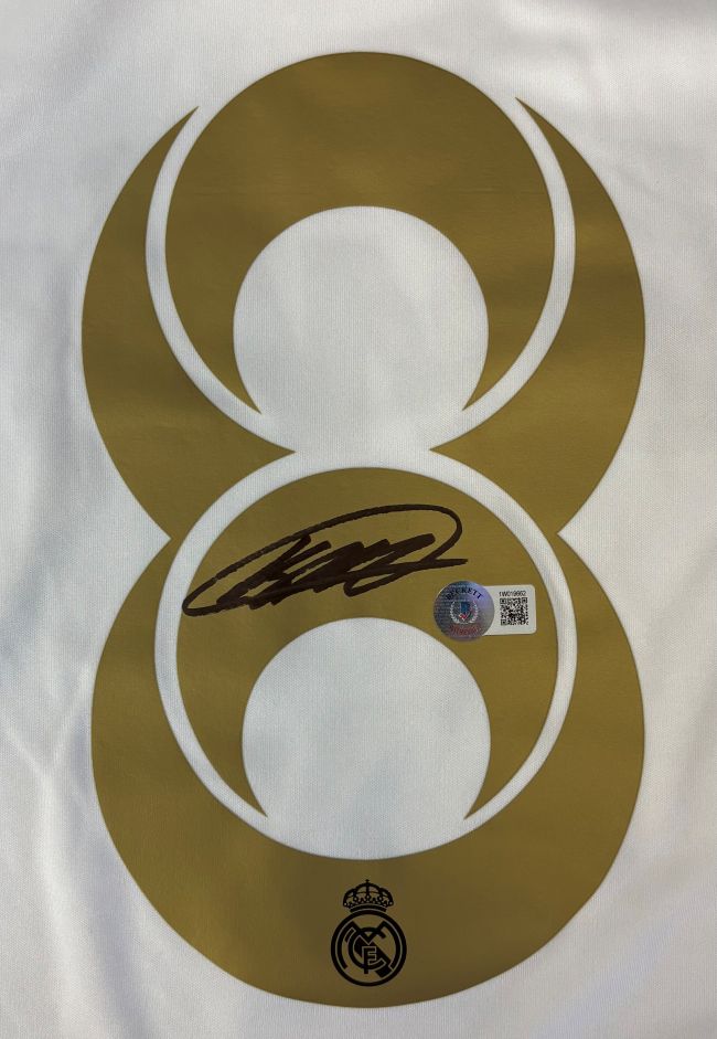 The Kaka Signed Real Madrid White Adidas Soccer Jersey 2 BAS by Sports Integrity features a gold number 8, black signature, authenticity sticker, and the Real Madrid logo on white fabric.