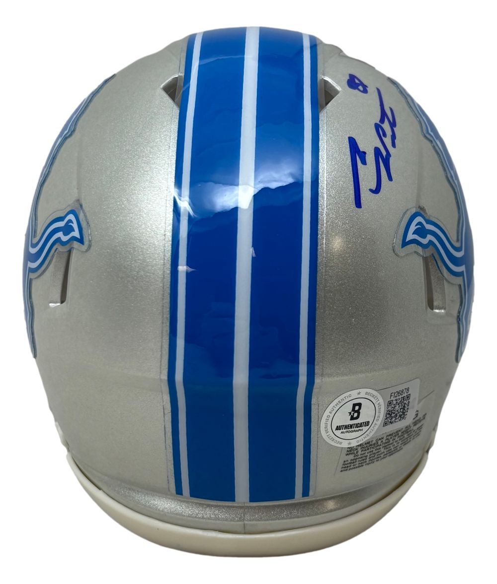 The Sports Integrity Sam LaPorta Signed Detroit Lions Mini Speed Helmet features blue stripes, the team logo, an autograph in blue ink, and an authenticity sticker on the back. Includes BAS certification and a display case.