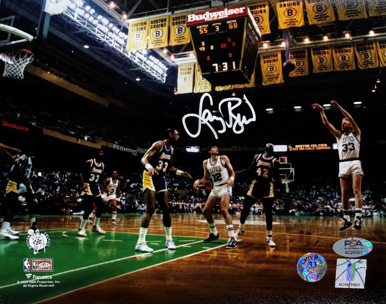 The Larry Bird Signed 8x10 Boston Celtics vs Lakers Photo by Sports Integrity shows Bird in a white Celtics uniform taking a jump shot over three Lakers defenders, with championship banners and a scoreboard visible above the court.