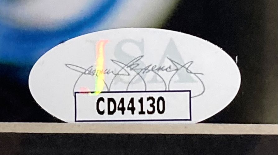 A Margot Robbie Signed Framed 8x10 Photo by Sports Integrity features a white oval JSA sticker with a multicolored watermark and bold black code CD44130 on a white rectangle in the center.