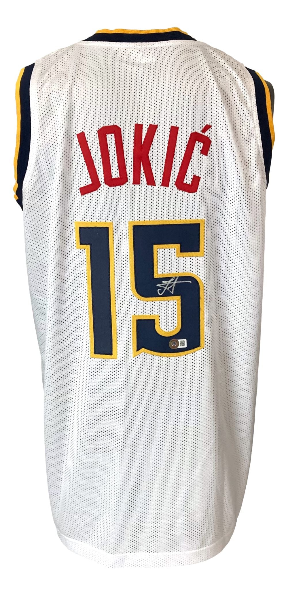 The Sports Integrity Nikola Jokic Denver Signed White Basketball Jersey BAS has navy, yellow, and red trim with "JOKIĆ" and number 15 in red and navy on the back, plus a small autograph below the number.