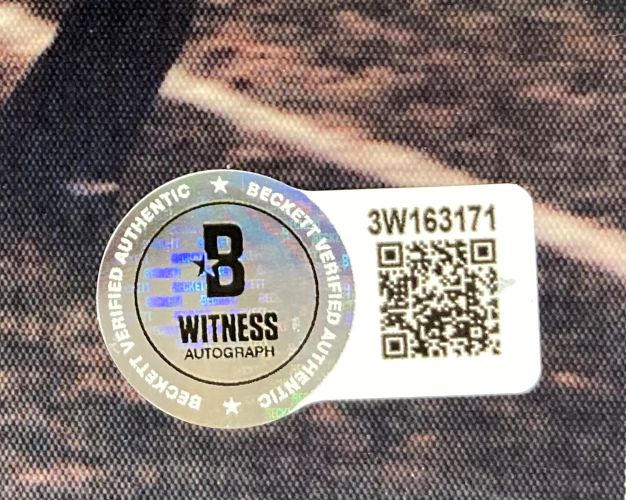 Close-up of a Beckett Witness Authentication sticker with holographic B, "Witness Autograph," and code 3W163171 next to a QR code on a Rudy Ruettiger Signed 8x10 Notre Dame Fighting Irish Photo by Sports Integrity.