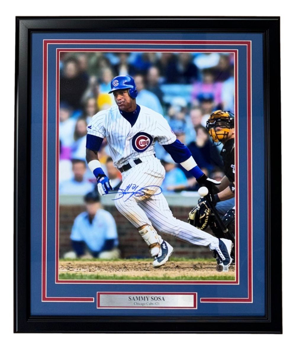 Sports Integrity Sammy Sosa Signed Framed 16x20 Chicago Cubs White Jersey Photo BAS features a photo of Sosa at bat in pinstripes, autographed and labeled Chicago Cubs #21.