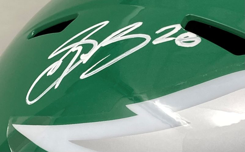 A Saquon Barkley signed Eagles FS Kelly Green Replica Speed Helmet by Sports Integrity, featuring his autograph with "#26" and a partial white lightning bolt design. Authenticated by PSA/DNA.
