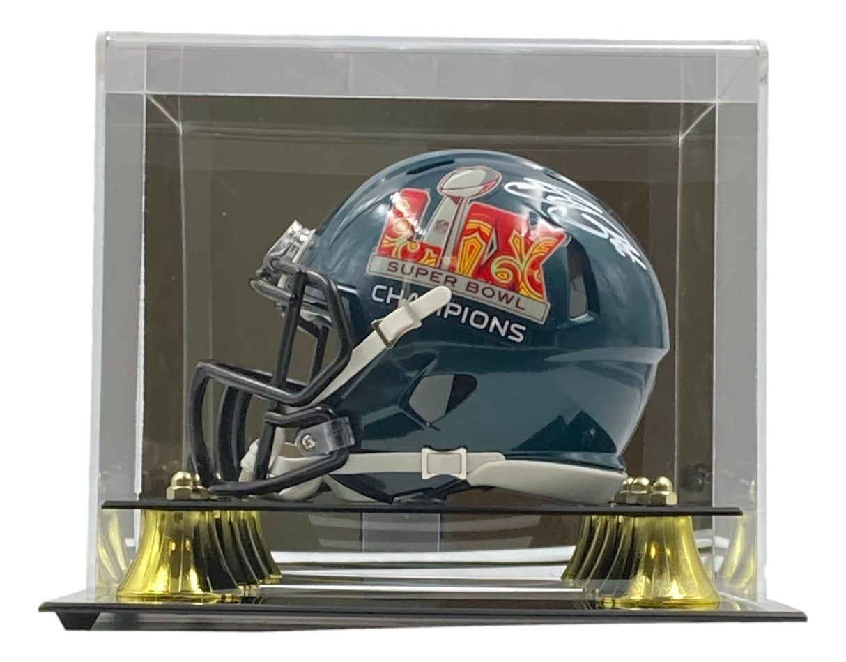 The Sports Integrity Saquon Barkley signed Eagles Super Bowl LIX mini helmet is displayed in a clear case with gold supports and features PSA/DNA authentication.