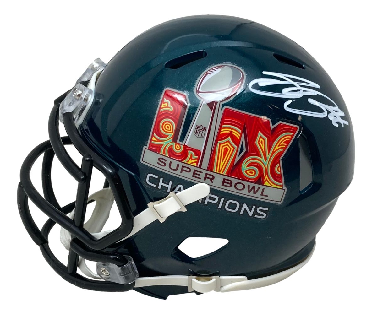 The Sports Integrity Saquon Barkley Signed Eagles Super Bowl LIX Mini Helmet features a dark green design, black faceguard, white chin strap, Super Bowl champions logo, white autograph, comes with a PSA/DNA case.