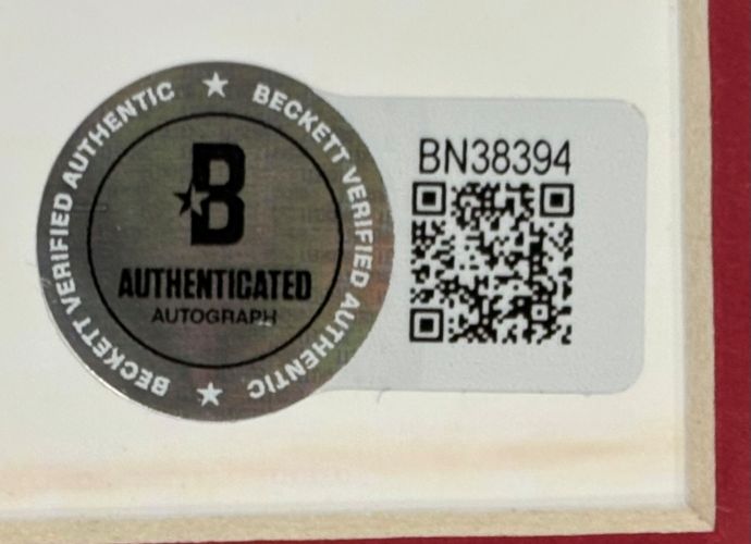 A Beckett Authentication Services sticker with a silver seal, QR code, and number BN38394 is attached to the Shane Wright Signed Framed 8x10 Seattle Kraken Photo by Sports Integrity.