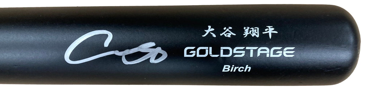 A close-up of a Shohei Ohtani Los Angeles Dodgers Signed Asics Game Model Bat by Sports Integrity, featuring “GOLDSTAGE Birch,” a white signature, and Japanese characters above the brand name.