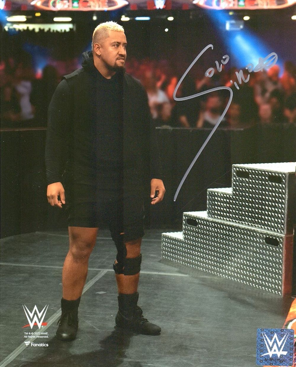 Solo Sikoa, in black gear with a knee brace, stands by metal steps in the WWE arena in this autographed 8x10 debut photo from Sports Integrity. Features WWE logos and certified authentic by Fanatics.