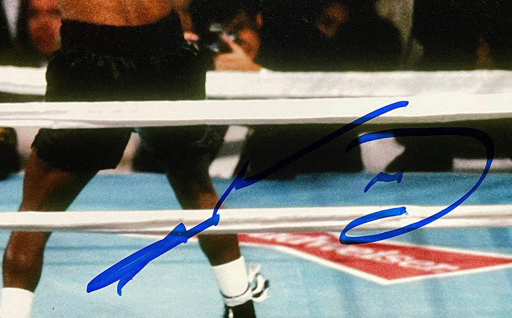 A Sugar Ray Leonard Signed 8x10 Boxing Punch Photo by Sports Integrity shows him in black trunks in the ring, with blue autograph visible. The boxer’s upper body is out of frame, and you can see ring ropes and part of the mat.