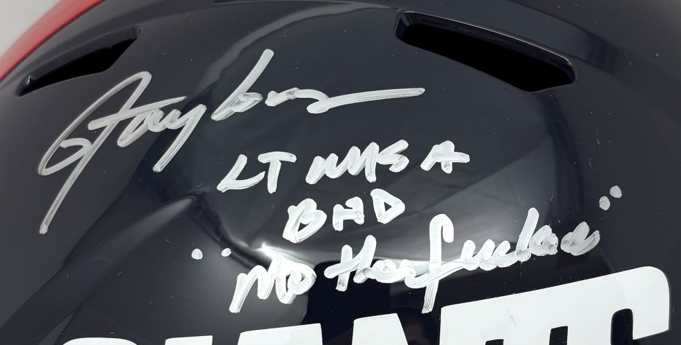 A close-up of the Sports Integrity Lawrence Taylor Signed New York Giants FS T/B Speed Replica Helmet BAD MF BAS, autographed in silver with “LT NYG #56 BHD No has beens.”.