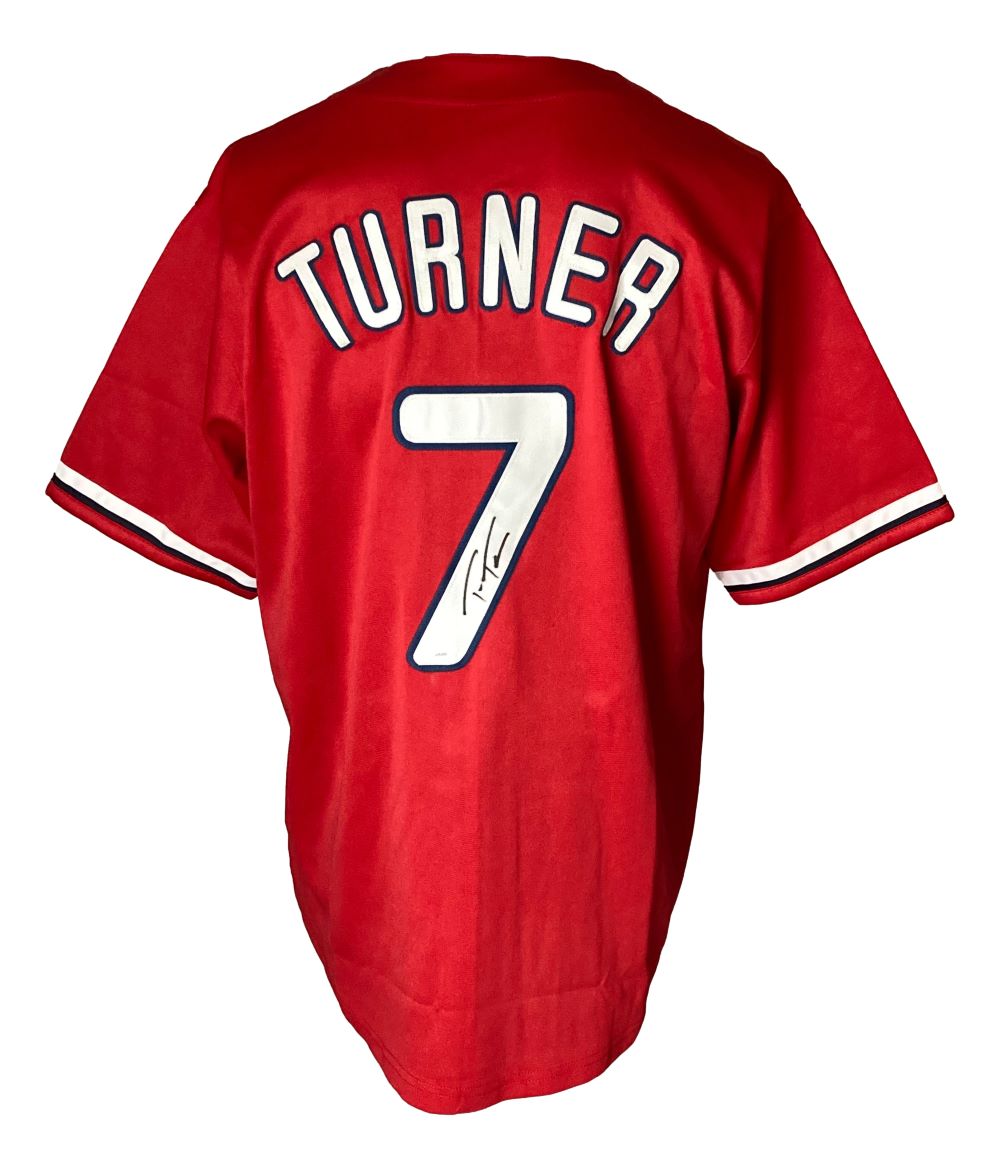 A Sports Integrity Trea Turner Philadelphia red baseball jersey with TURNER and #7 in white on the back, plus #7 featuring a black autograph below its left side. JSA authenticated.